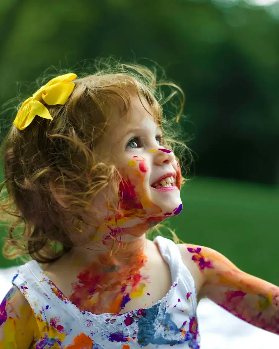 Lachendes Kind beim unbeschwerten Spielen mit Farben